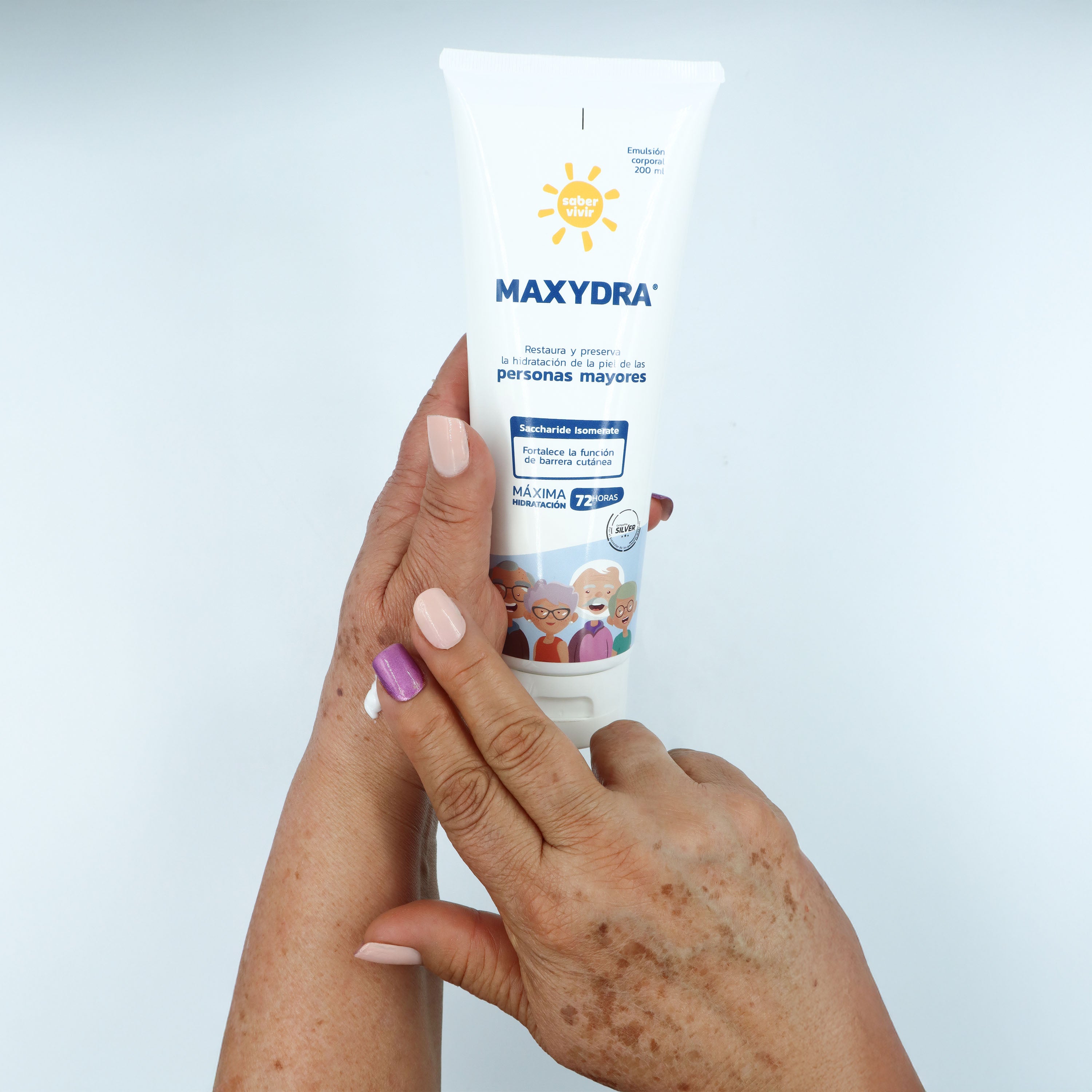 Manos de persona mayor aplicando crema hidratante sobre la piel.